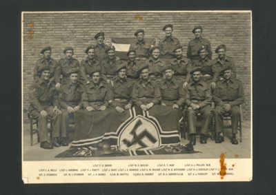 Army group photograph - 79 A.S.R.E. 79th Armoured Division - Holland - 1945 - with captured Nazi flag - S.S.M. Maurice Whittle front row 4th from left; 3593 Army group photograph - 79 A.S.R.E. 79th Armoured Division - Holland - 1945 - with captured Nazi flag - S.S.M. Maurice Whittle front row 4th from left; 3593