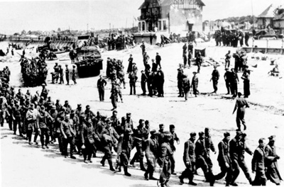 Photograph - produced for propaganda purposes - captured German troops on the beach at Bernier-sur-Mer - D-day - 06/06/1944; 6/06/1944; 37902 Photograph - produced for propaganda purposes - captured German troops on the beach at Bernier-sur-Mer - D-day - 06/06/1944; 6/06/1944; 37902