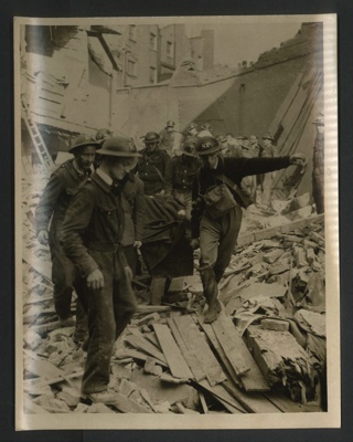 Official copyrighted war photograph- 20th October 1940- man rescued from his demolished home is carried to safety by stretcher bearers; 56554
