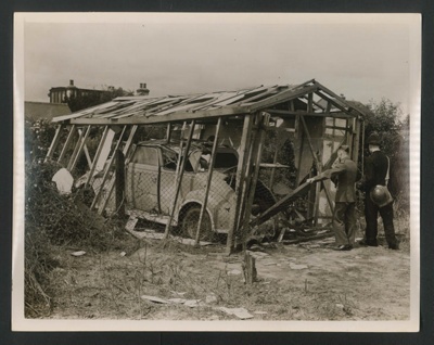Official copyrighted war photograph- 19th June 1940- wrecked car and garage; 56541