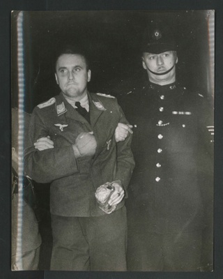 Official copyrighted war photograph - undated - Nazi airman prisoner under escort at a London station; 56576