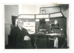 Photograph - person unknown - sitting in front of a control desk; 36358