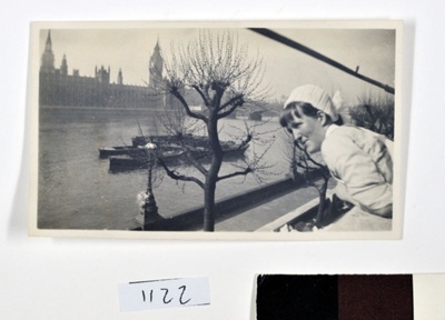 Nurse peering over a balcony overlooking the River Thames and Houses of Parliament; 1938; 1122