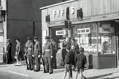 fht.2026.104  raf kinloss, battle of britain parade personnel, at bill fyfe's removals shop at 143 high street, 16th september 1962. bob ross took over this shop next, as a bookmakers.
