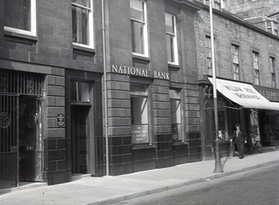 fht.2026.97  national bank (no 57 high street),william ross, shoemaker (no 55), and jl geddes, clothier (manchester house) (no 53) pictured circa 1955