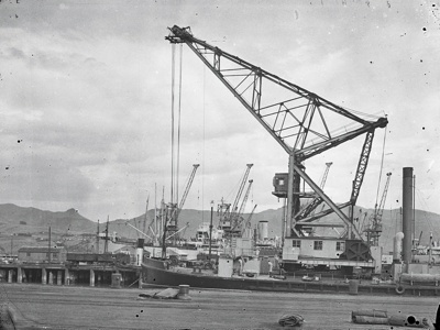 Reverse Image Shipping, "Rapaki," 1926, 762 GRT. the Lyttelton Harbour Board 80 Ton Floating Steam Crane. Berthed at her Wharf, Lyttelton Port, Canterbury, New Zealand. image item