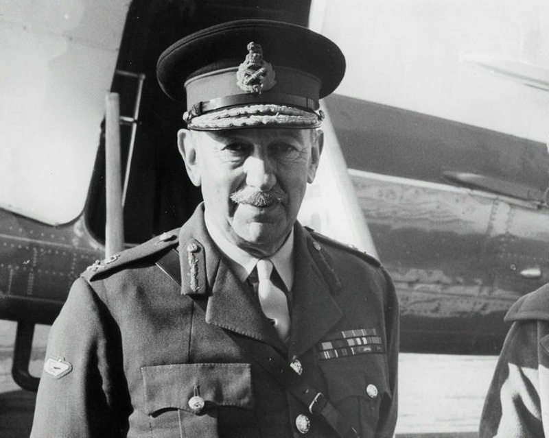 Army. This soldier is a Lieutenant-General, Indicated by the Crown and Crossed Sword and Scabbard on his Lapel and the red Flashes on His Lapels. The WWI Tank on his Right Sleeve Indicates his Involvement in the Armoured Corps. He is Standing in Front of an Unidentified Aircraft. New Zealand. A Governor General??