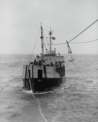 Naval. US Yard Oiler 34, YOG 34, Transferring goods between vessels by means of Breeches Buoy. At Sea. New Zealand. image item