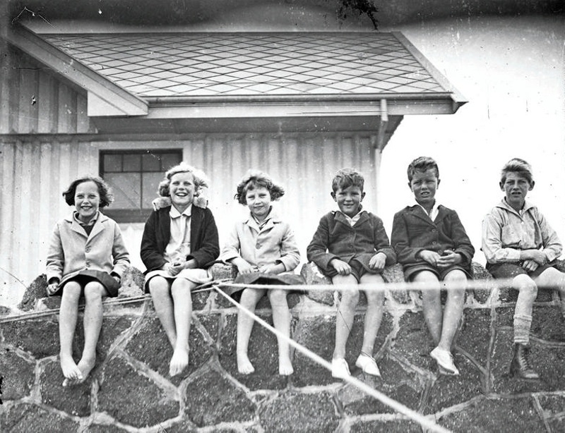 Children Sitting on Stone Wall. Christchurch, Canterbury, New Zealand.