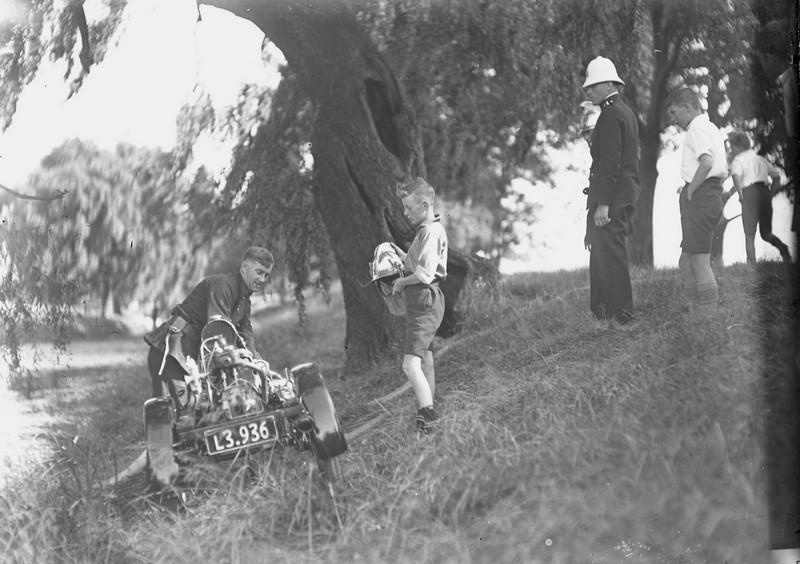 Fire. Fire Brigade Training with Light Trailer Pump. Police and Boys Present Brass Helmet Days. Avon River. Christchurch, Canterbury, New Zealand. 2