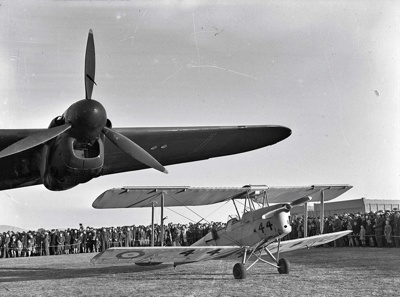 Aviation. RAF. Royal Air Force Avro Lincoln Bomber. A73-24. Under the Wing is a RNZAF Royal New Zealand Air Force Trainer, a De Havilland Tiger Moth DH 82a Aircraft NZ-1444. Crowd of Onlookers. Wigram, Christchurch Canterbury, New Zealand. image item