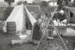 A woman and girl in costume outside the tent by the fireplace on the green at Howick Historical Village.; La Roche, Alan; P2021.88.17