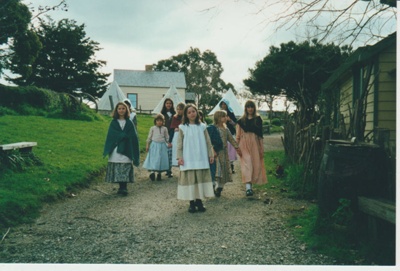 Girls in costume, walking down Church Street at the Howick Historical Village; La Roche, Alan; 2019.102.01