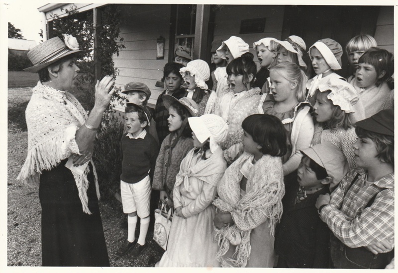 A school group,all in costume, singing outside Brindle Cottage in the Howick Historical Village.