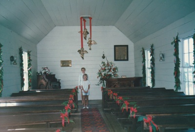 Christmas, past and present at Howick Historical Village, 12 December 1987. Two girls in the decorated church.; 12 December 1987; P2021.190.23