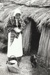 A woman in costume outside the Sod Cottage, Howick Historical Village. ; May 1995; P2020.45.09