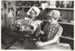 Two children in costume, acting as shopkeepers in White's Store.; N.Z. Herald; July 1983; P2020.84.01