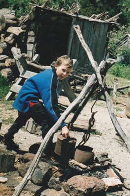 A boy by the fireplace on the green at Howick Historical Village.; La Roche, Alan; October 1996; P2021.88.16