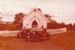 Two vintage cars being driven away from the Methodist Church in Howick Historical Village.; 16 November 1980; P2021.108.06