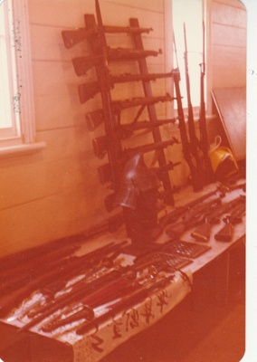 A display of firearms in Pakuranga School in Howick Historical Village as part of the International Military Arms Society display.; La Roche, Alan; 23 August 1980; P2021.100.05