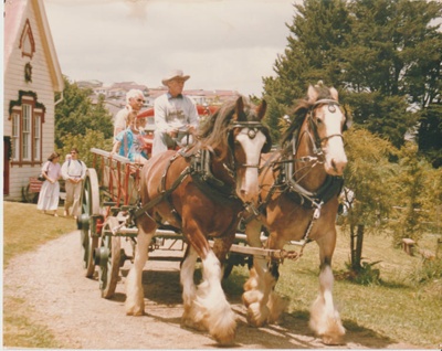 People in a wagon pulled by two Clydesdale horses outside the Pakuranga School; 2019.136.01
