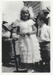 A girl, possibly Mary Brickell, and a boy standing  on Picton Street with others waiting to see the 1947 Centennial Parade.; 8 November 1947; P2022.38.48