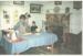 Rosemary McLean supervising a boy making butter in Johnson's cottage in Howick Historical Village. ; c1985; 2020.123.01