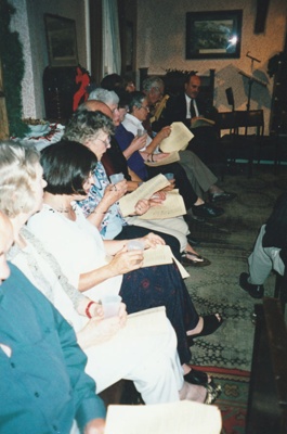 Puhinui living room with Carol singers at Howick Historical Village, December 2000.; La Roche, Alan; 2 December 2000; P2022.05.05