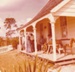 Visitors watching guides in costume spinning on the verandah at Sergeant Barry's cottage in Howick Historical Village. ; c1980; P2020.132.01