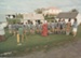 Boys from Saint Kentigern's College with guides in costume onthe Village green in Howick Historical Village during a school visit.; March 1982; P2021.183.01
