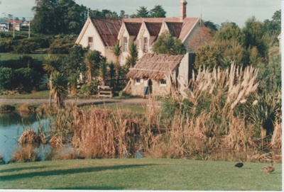 Looking across the pond to the sod cottage and PuhiNui.; Harris, Josie; 1980s; 2019.105.01