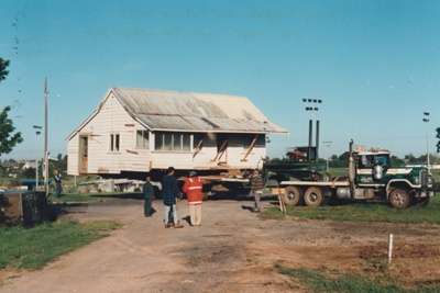 Fitzpatrick's Cottage on its new site at Howick Historical Village. The 
transporter is moving away.; Smith, Christina; November 1997; P2021.79.04