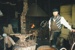 An unnamed volunteer standing with one front resting on the water barrel in front of the firebox in Wagstaff's Forge in Howick Historical Village on a Live Day.; La Roche, Alan; c2000; P2021.03.14