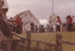 Visitors are watching the Pioneer Guard fire the cannon on the green in front of the Couthouse at Howick Historical Village during the 1080 Gala in October 1984.; La Roche, Alan; October 1984; P2021.173.29