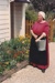 Debbie Benson in costume as Maggie Thompson in front of a cottage garden at a Live Day at  HHV.; December 2002; 2019.199.07