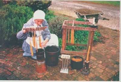 Penny Hill in costume making candles at Howick Historical Village.; c1985; 2019.138.01