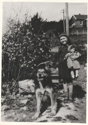 Shirley Hattaway holding a doll at Whitford with Rover the cattle dog bside her.

; P2021.165.05