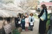 A group of Asian school children and a teacher outside the raupo hut in Howick Historical Village.; P2021.107.16