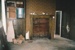 Puhinui kitchen before restoration, showing the fireplace, a water cylinder and workbench.; Alan La Roche; May 2002; P2020.14.06