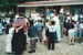 A group of school children and guides, in costume, outside Brindle Cottage in Howick Historical Village.; 1995; P2021.107.19