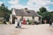 Two girls carrying a bucket of water in front of Briody-McDaniel cottage. ; 22 August 2006; 2019.196.04