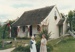 Christmas, past and present at Howick Historical Village, 12 December 1987. Two volunteers in cosstume in front of Sergeant Barry's cottage.; La Roche, Alan; 12 December 1987; P2021.194.09
