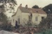 Kay Langdon's cottage at 33 Drake Street, Howick before its removal to Howick Historical Village to become Brindle Cottage. Shows men removing the shingles which were underneath an iron roof.; La Roche, Alan; June 1977; P2021.38.07