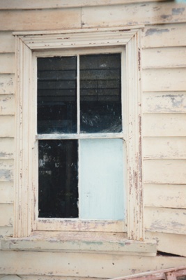 The rear window of Sergent Ford's cottage, built c1925 with the original yellow ochre paint.; La Roche, Alan; August 1995; P2021.51.10