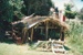 Hemi Pepene's whare (cottage) at the Howick Historical Village, showing the thatched roof and iron.; La Roche, Alan; December 2000; P2020.96.04