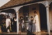 Five ladies in period cotume on the verandah of Sergeant Barry's cottage in Howick Historical Village. ; La Roche, Alan; 1985; P2020.139.01