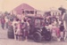 A vintage car surrounded by people in Howick Historical Village. De Quincey's and Johnson's cottages are in the background.; La Roche, Alan; 11 October 1981; P2021.108.15