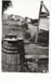 Looking across grass to the Forge showing a White's Store sign and a barrel.; Eastern Courier; 19 February 1992; P2020.75.01