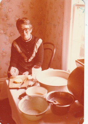 Claire Lees in costume, making butter in Howick Historical Village on a Live Day..; August 1980; P2021.105.34