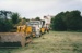 A Truck towing heavy vehicle following a bulldozer clearing the way for moving half of Puhinui to its new site in the Howick Historical Village. ; Smith, Malcolm; May 2002; P2020.16.05